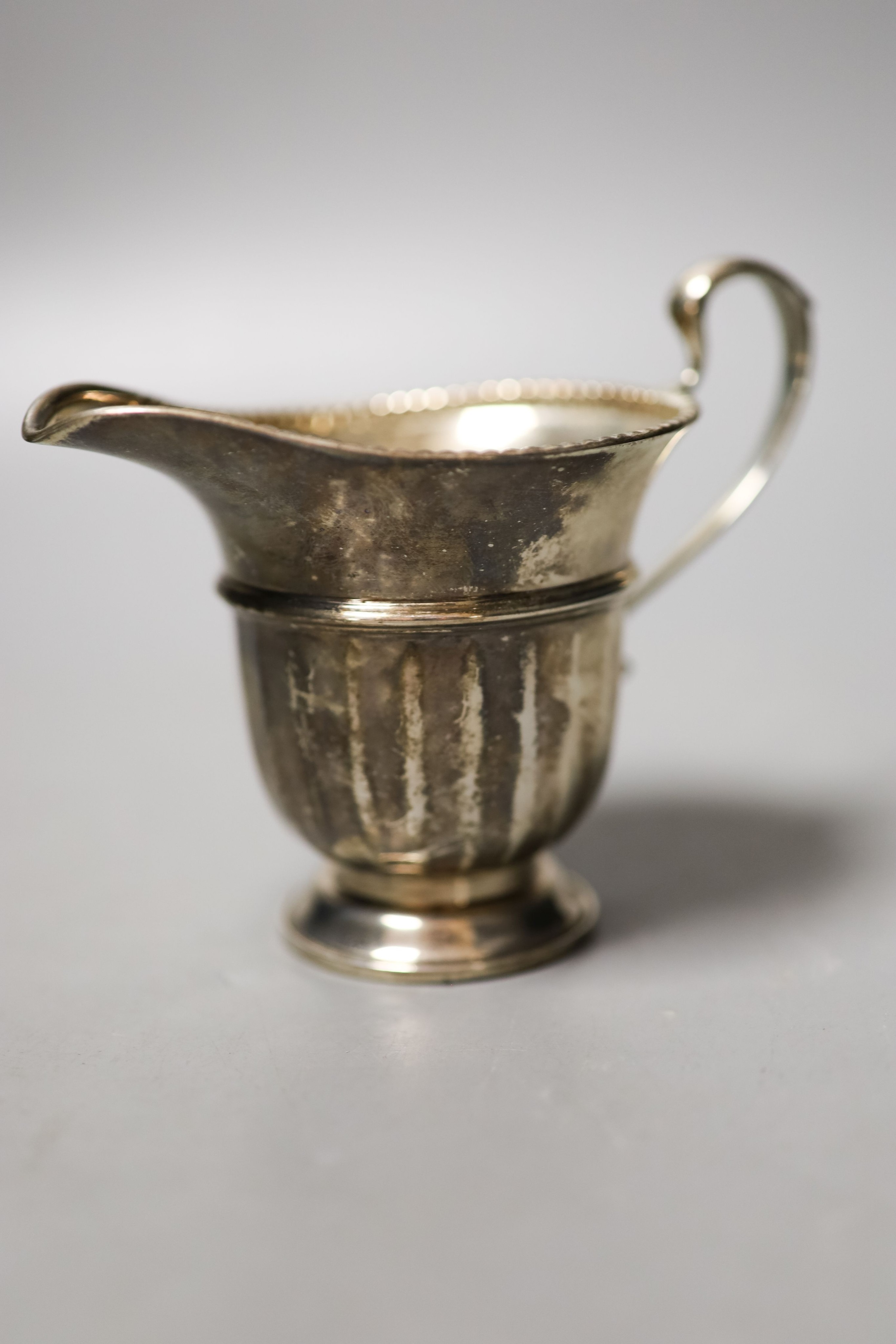 A George V silver circular three piece tea set, Birmingham, 1931/2, gross weight 18.5oz.